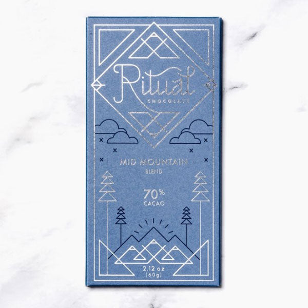 Blue packaging with silver foil writing and design of geometric mountain and trees.