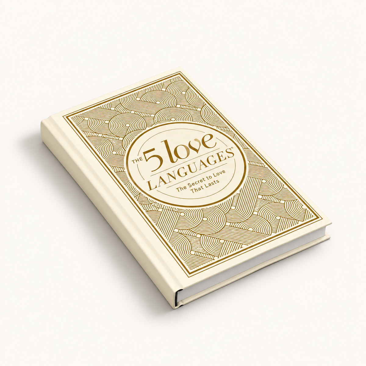 The 5 Love Languages book with a cream-colored cover and gold geometric patterns, shown at an angle on a light beige background.