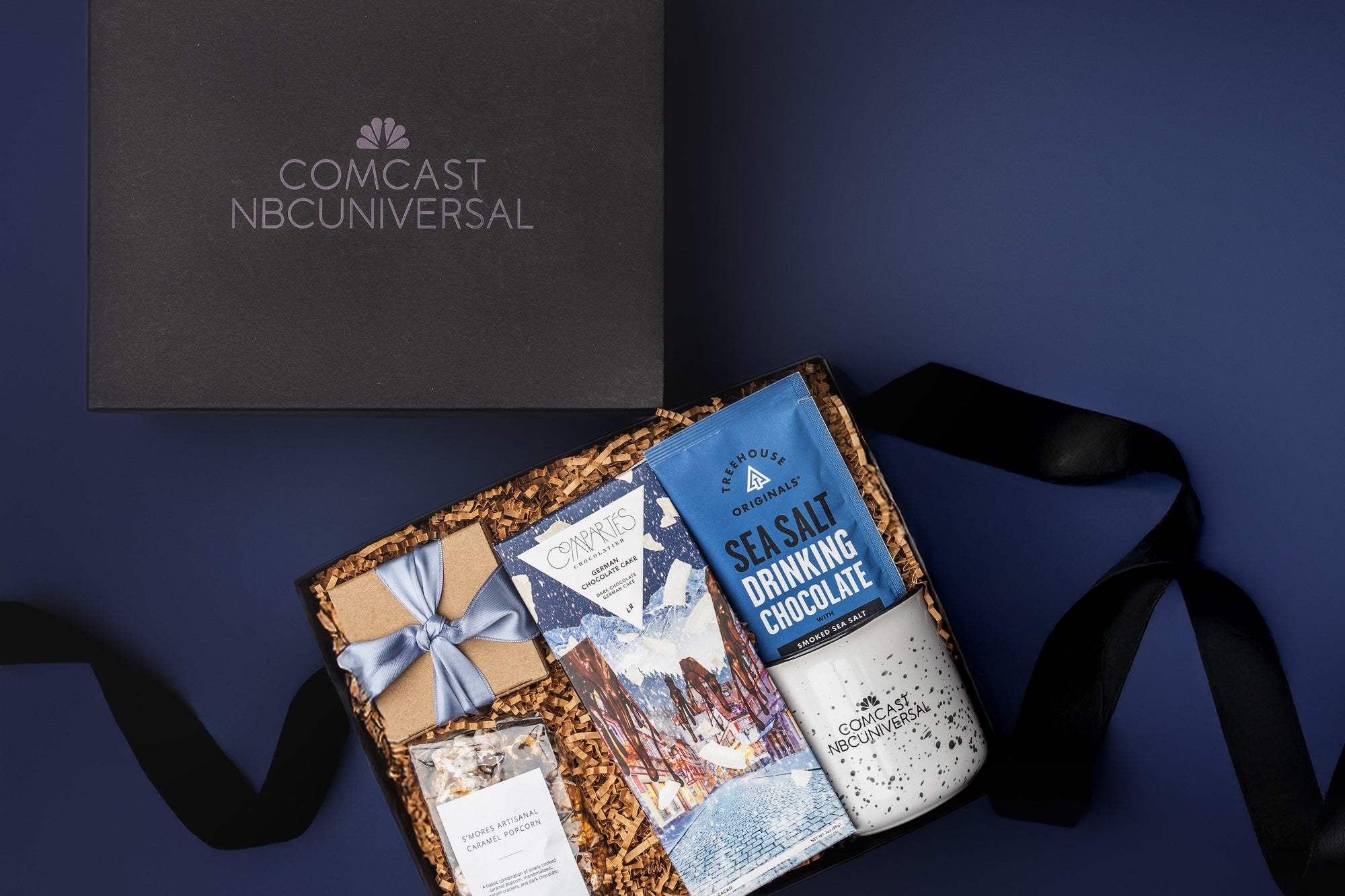 Uniwue branded holiday gift for client gifting, with hot cocoa, custom logo mugs, caramel popcorn and chocolate bar.