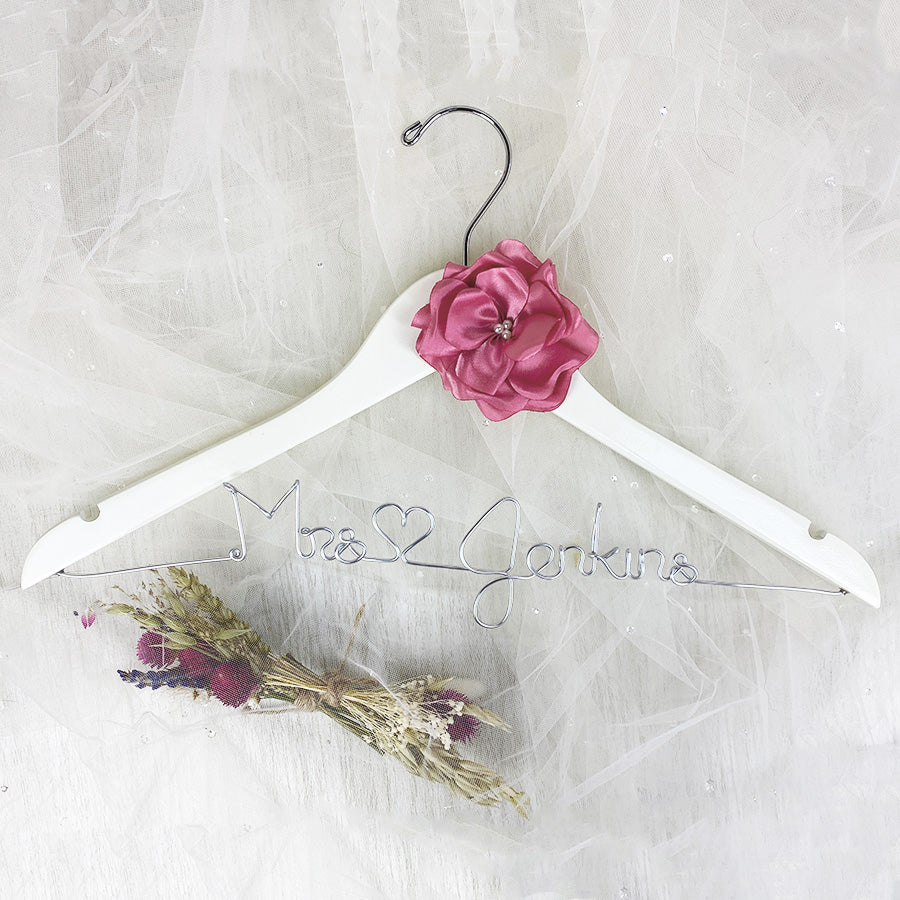 Light wooden hanger with satin flower and silver hook. Personalized base wire shaped into name
