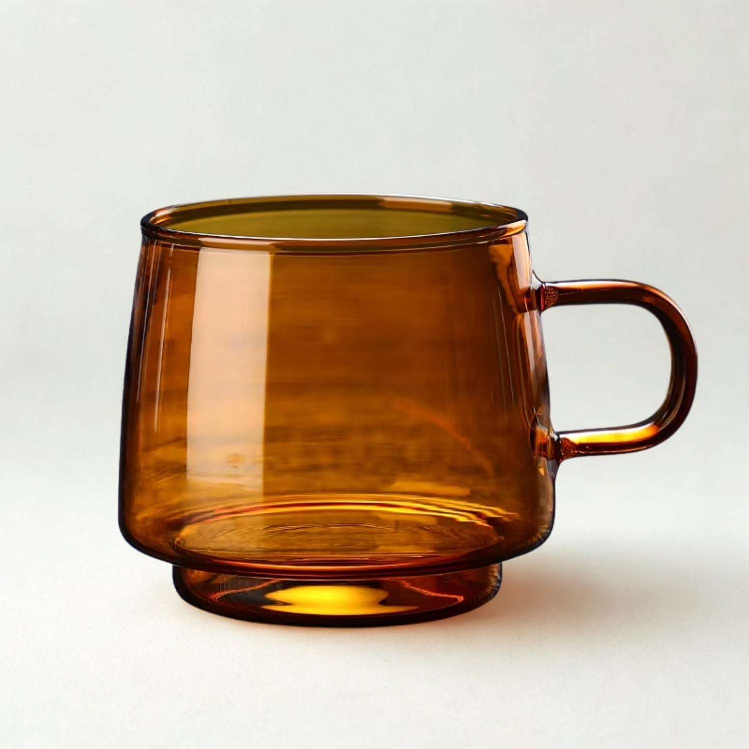Amber mug circular shaped amber colored glass mug on a white background. 