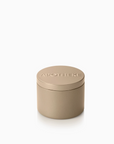 A small cylindrical metal tin with a matching lid, embossed with the brand name 'APOTHEKE', in a warm taupe-beige color, set against a clean white background.