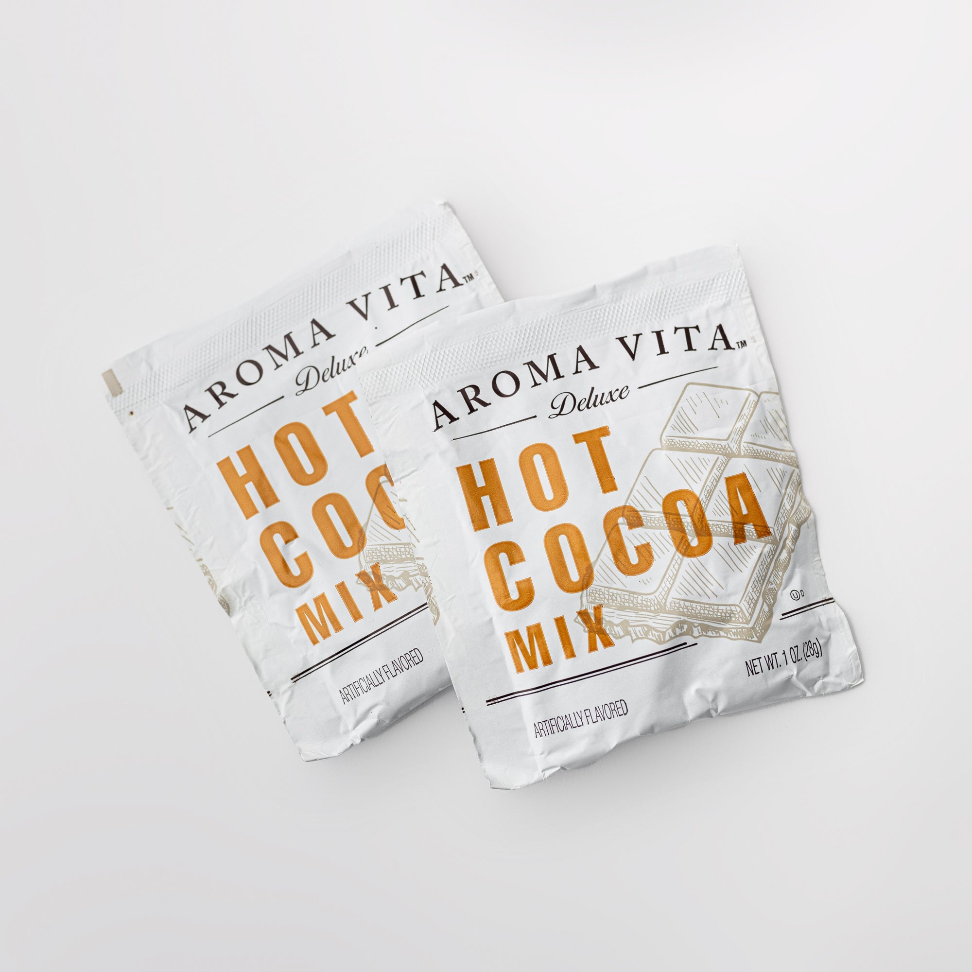 Two packages of Aroma Vita Hot Cocoa Mix on a light gray background