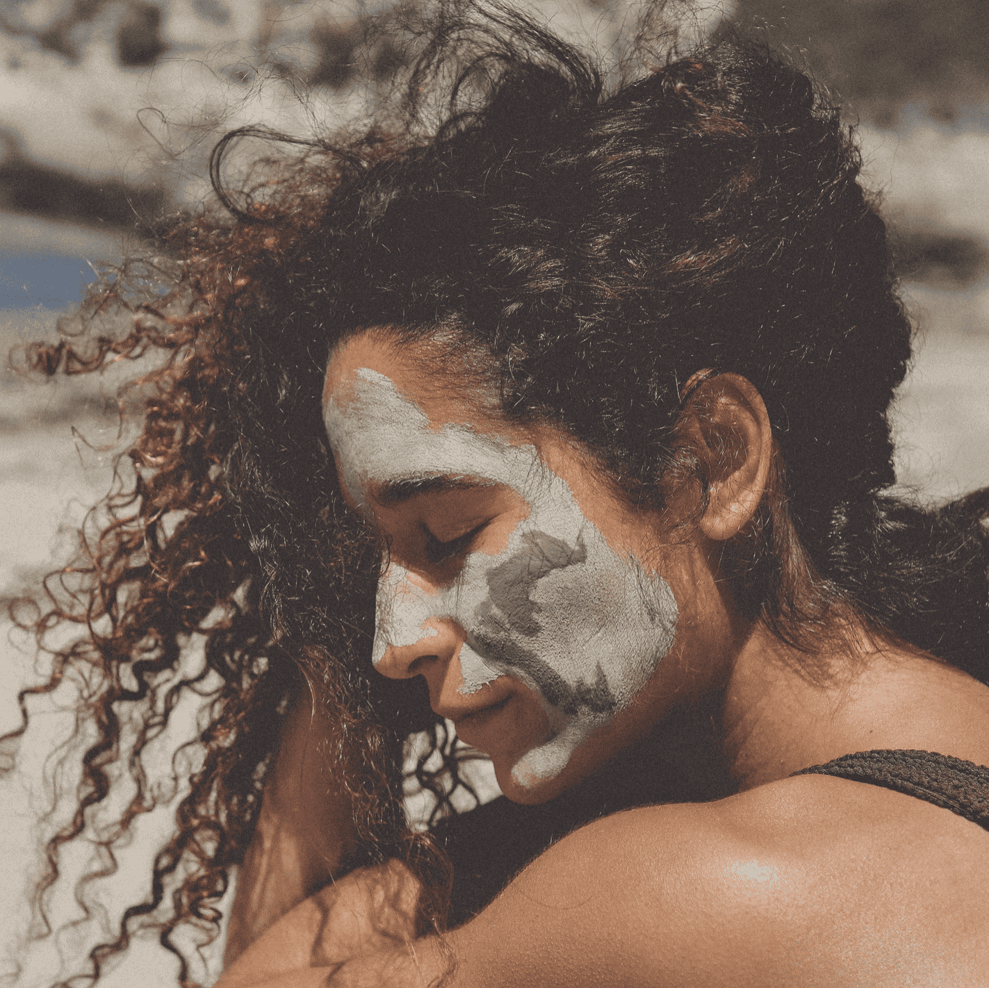 Person with green face paint embracing another person outdoors