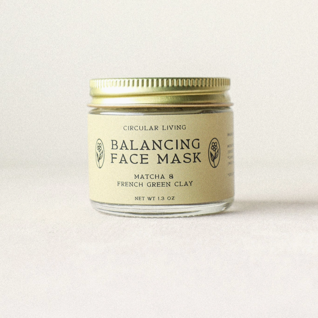 Balancing face mask jar with gold lid on a light background