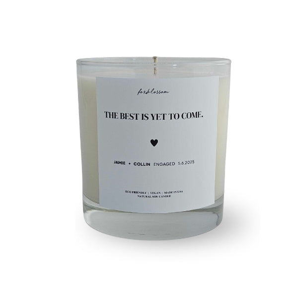 Candle with a label reading 'The best is yet to come' on a white background