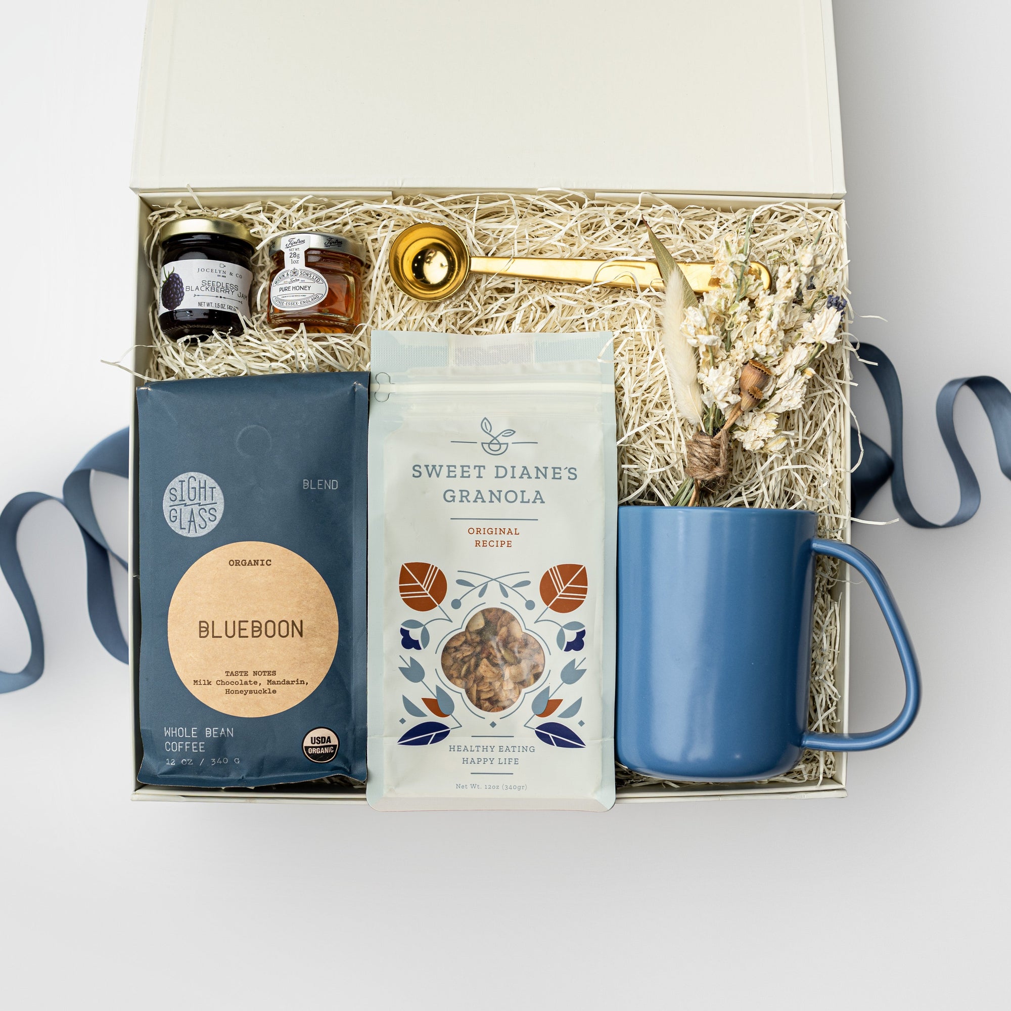 Gift box with a blue mug, soap, and other items on a white background