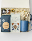 Gift box with a blue mug, soap, and other items on a white background