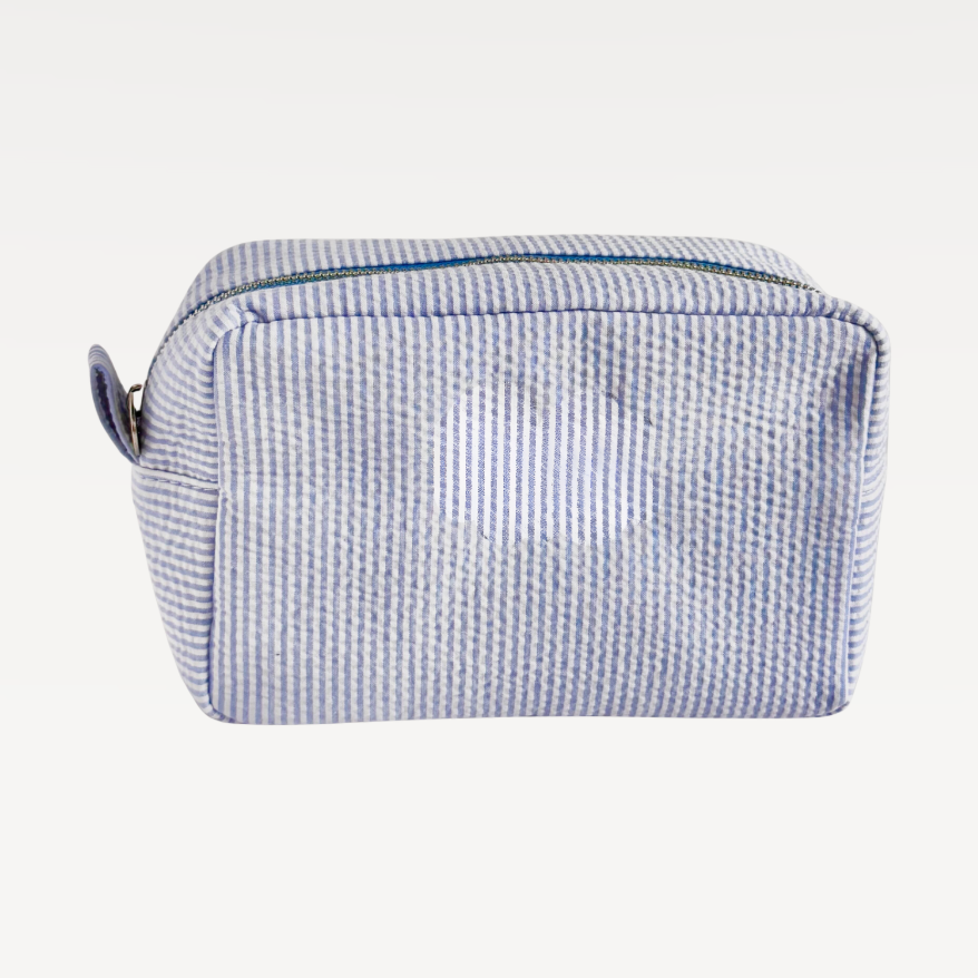 Rectangular cosmetic makeup bag with blue and white horizontal stripes and a top zipper closure.