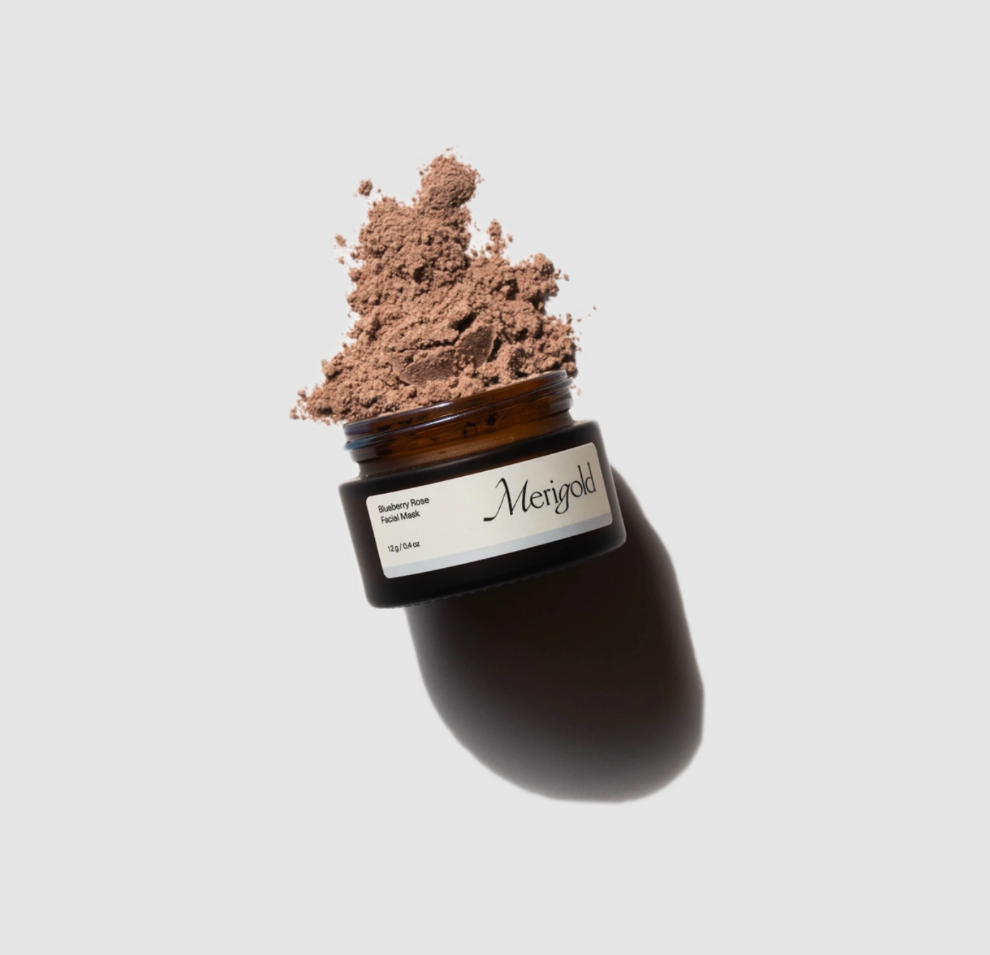 Picture of the blueberry rose facial mask open showing the brown powder inside. 