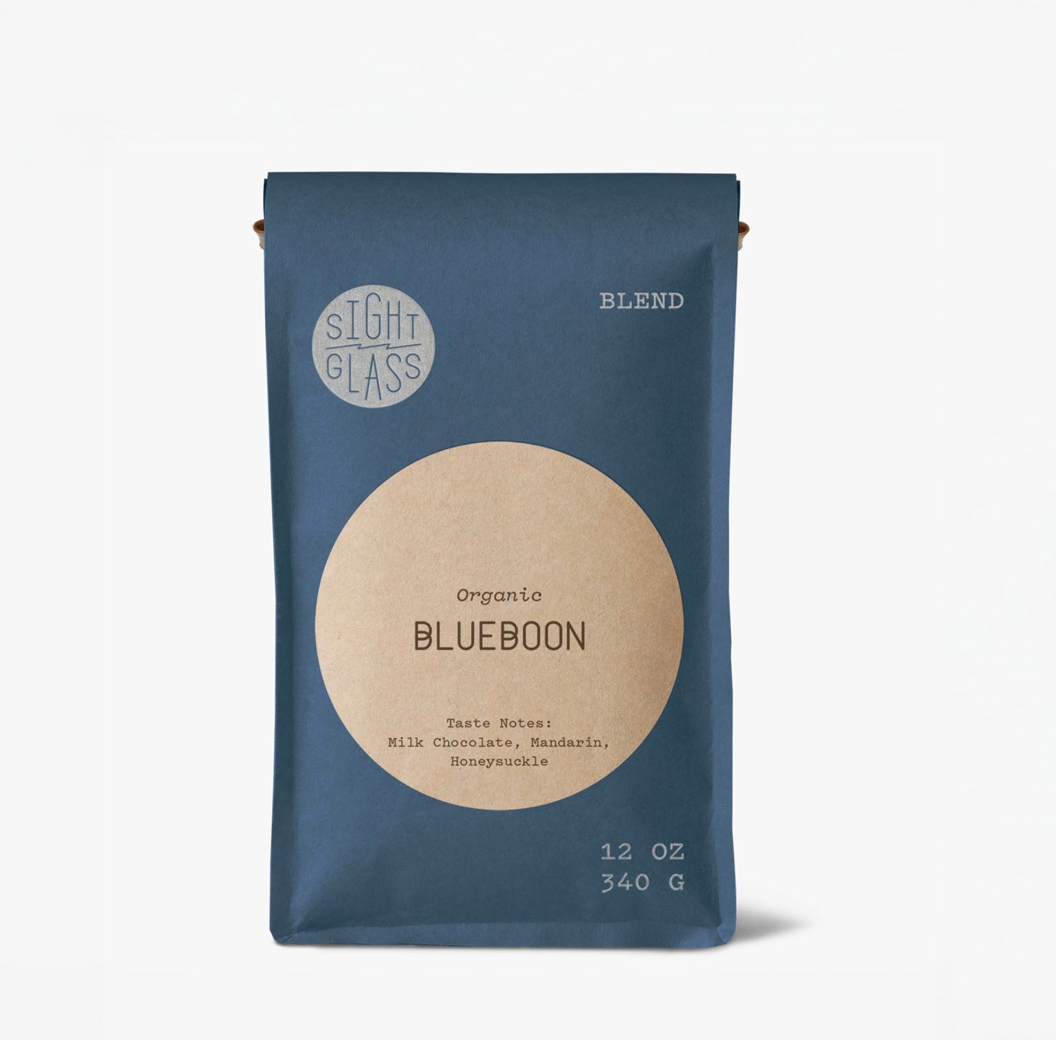A 12 oz bag of Slight Glass Organic Blueboon coffee blend, featuring a dark slate blue bag with a large beige circular label and white text, set against a clean white background.