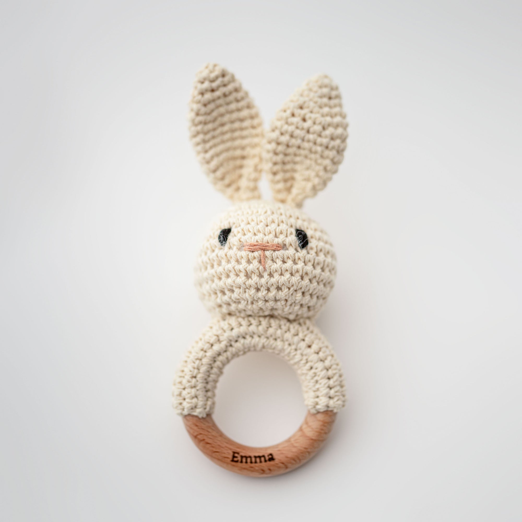 Bunny baby rattle is featured a ring with and embroider bunny rattle attached and the wooden part is personalized with the name Emma.
