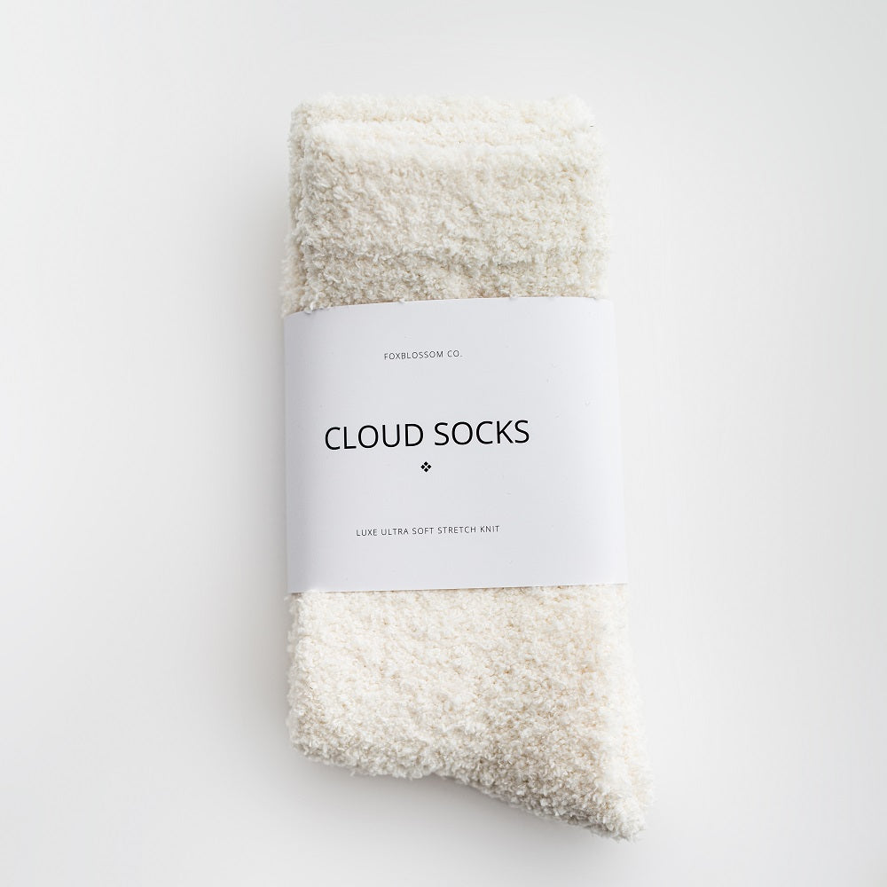 Our signature cloud socks are ivory in color with a white label with black lettering on a white background shown.