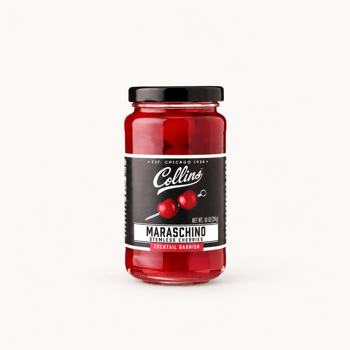 A glass jar of Collins Maraschino Cocktail Barnish with red maraschino cherries, a black lid, and a black label with white text, centered on a light off-white background.