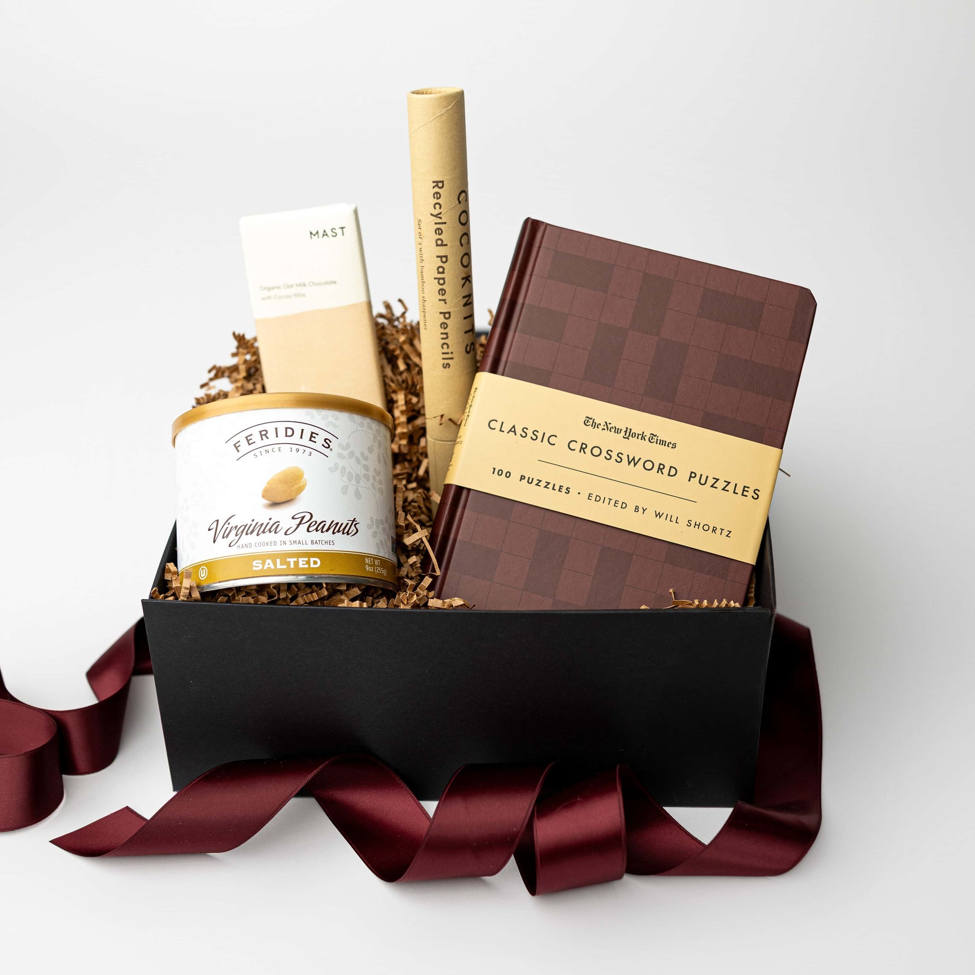 Gift basket with a book, bottle, and other items on a white background