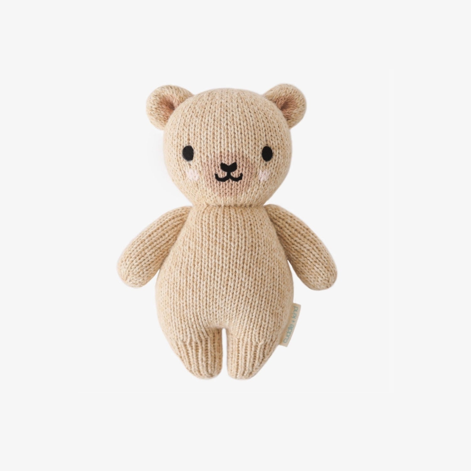 Handcrafted Cuddle + Kind Baby Bear plush in soft neutral knit fabric, sitting upright on a clean white background, featuring stitched facial details and a cozy handmade texture.