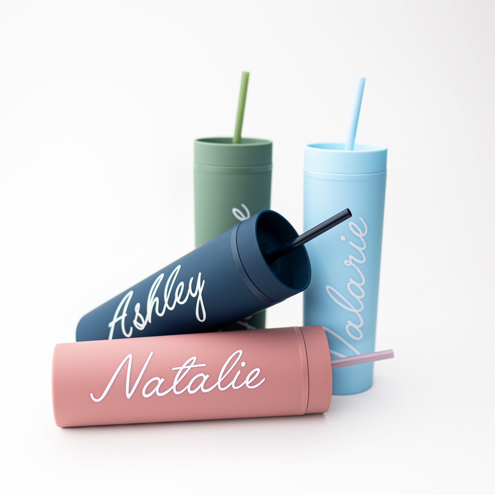 Our custom tumblers with straw shown in the four colors they come light blue, navy, green and rose. Personalized in white lettering with the names Valerie, Ashley, Jasmine and Natalie on a white background.  