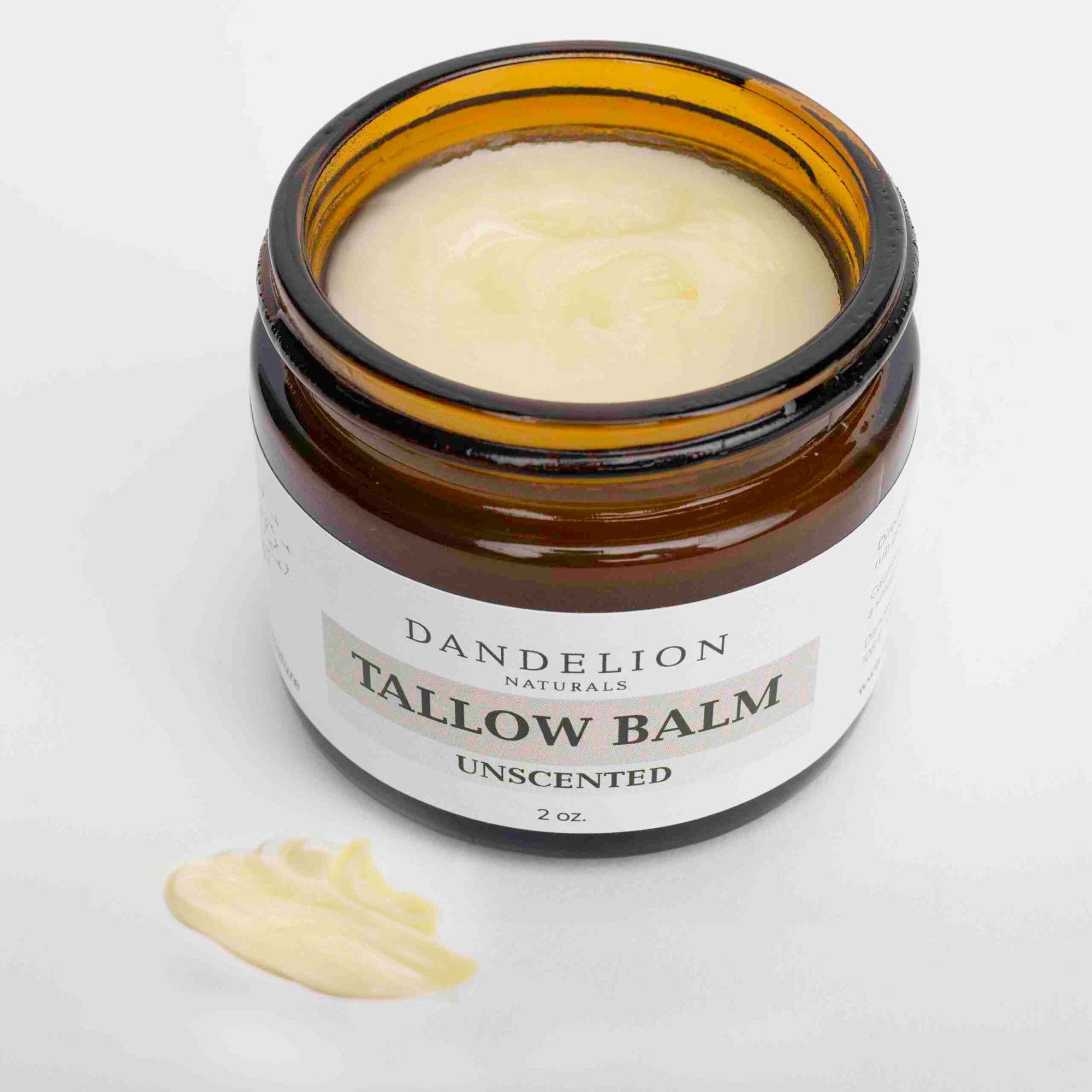 Dandelions naturals unscented tallow balm opened in its amber container on a white background. 