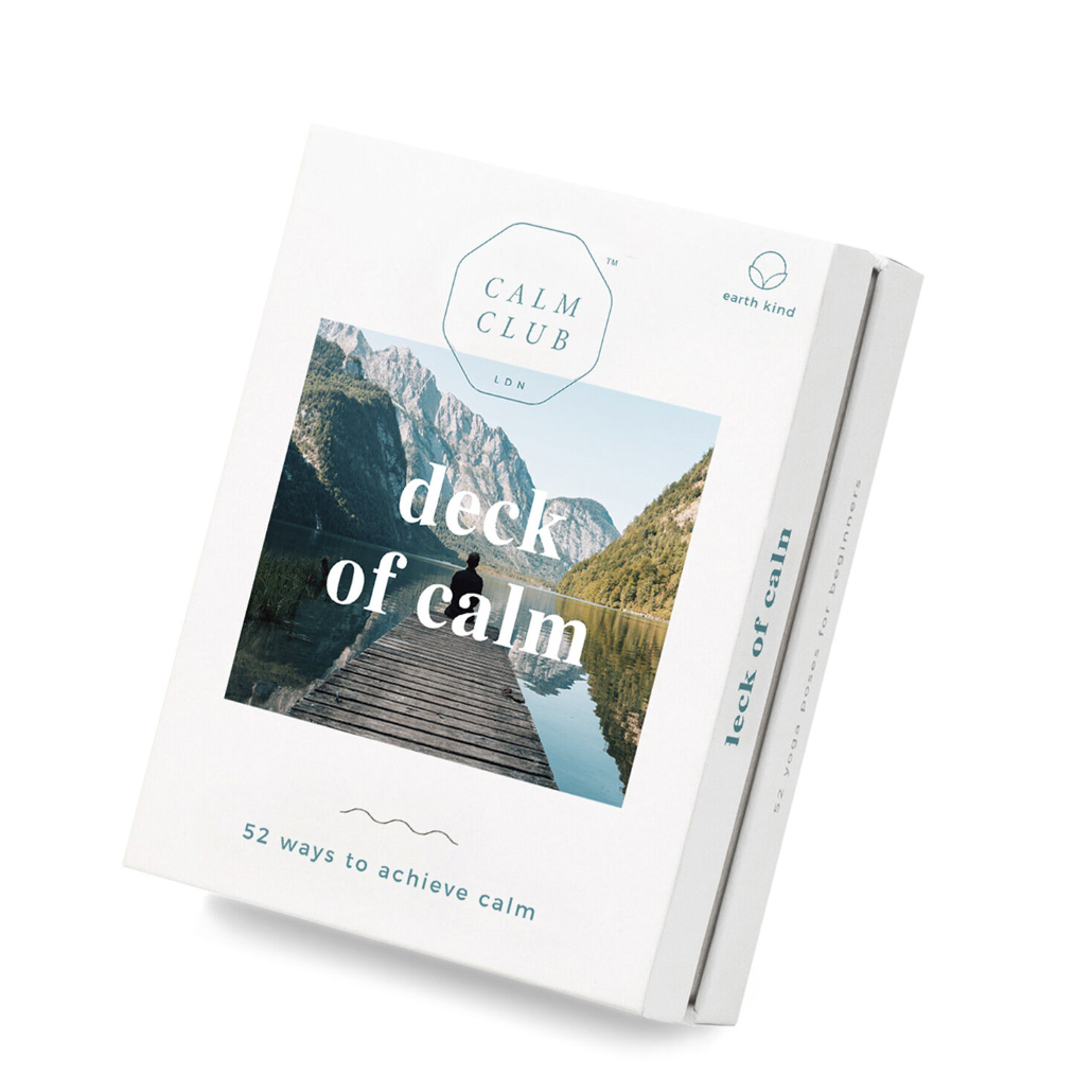  Deck of calm  featured, the image is the "Calm Club" deck of cards,  The front of the box displays an image of a person meditating on a wooden dock overlooking a calm lake, mountains in the background, which is meant to evoke tranquility. With text overlayed on the image describing the product name and the number of ways to achieve calm. The side of the box showcases the product's description and purpose. 