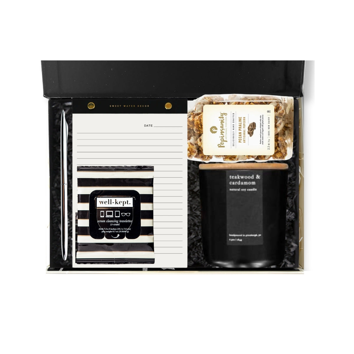 A curated gift set in a black presentation box, featuring a black and white striped notepad, a black and white striped mug with a 'well.kept.