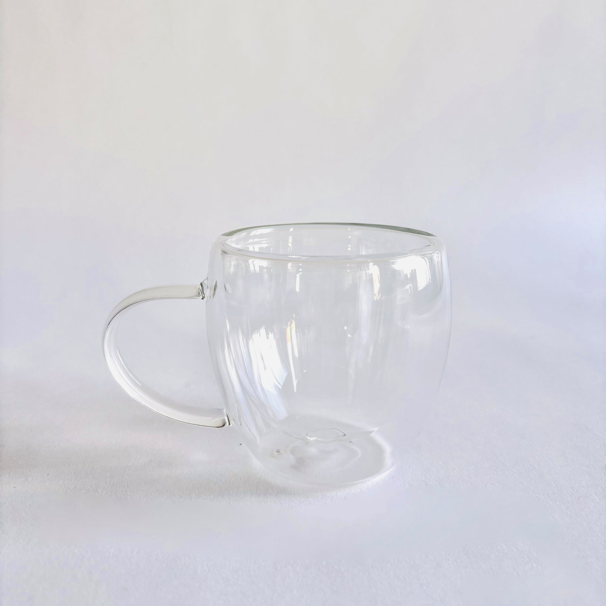 Double walled glass coffee cup is featured on a white background. 