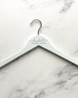 Engraved bride hanger is featured in a white hanger personalized Elizabeth- mother of the bride in a marble like background. 