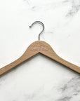 Engraved bride hanger in natural personalized with Cameryn matron of honor on a marble-like background.