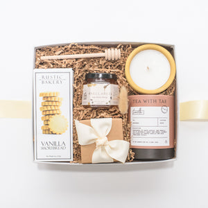 Relaxing gift box with vanilla shortbread cookies, raw clover honey, handpoured candle, small batch tea, sea salt caramels, and a honey drizzler. Appreciation gifts, housewarming gifts, anniversary gifts.