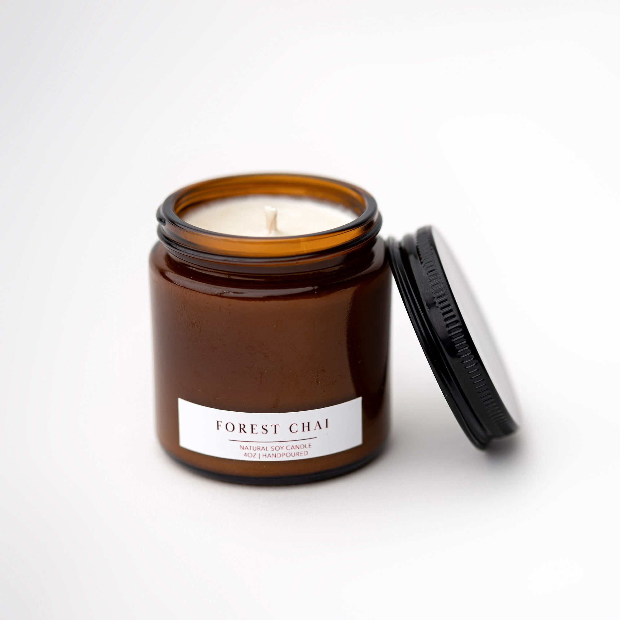 Forest Chai candle featured in its amber glass jar and white label with dark brown lettering on a white background.