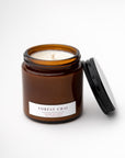 Forest Chai candle featured in its amber glass jar and white label with dark brown lettering on a white background.