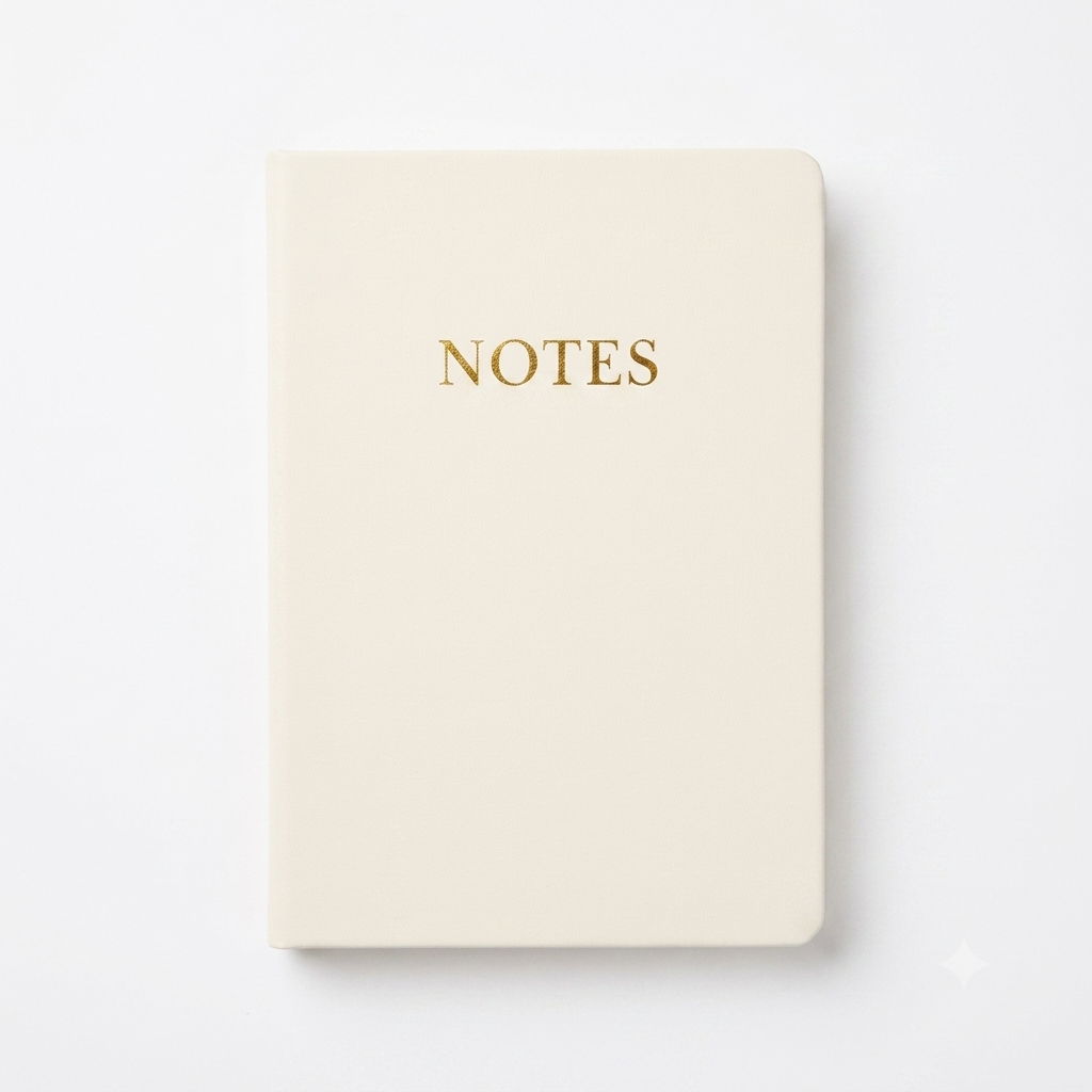 White soft cover notebook with notes in gold lettering on a white background. 