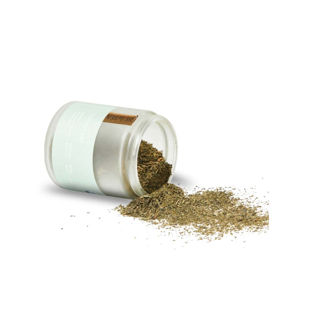 Glass jar with dried herbs spilling out on a white background