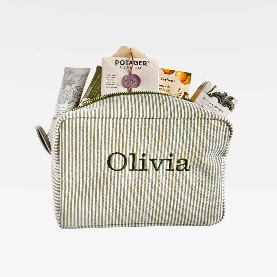 Green striped pouch with 'Olivia' embroidered on it, containing various items.