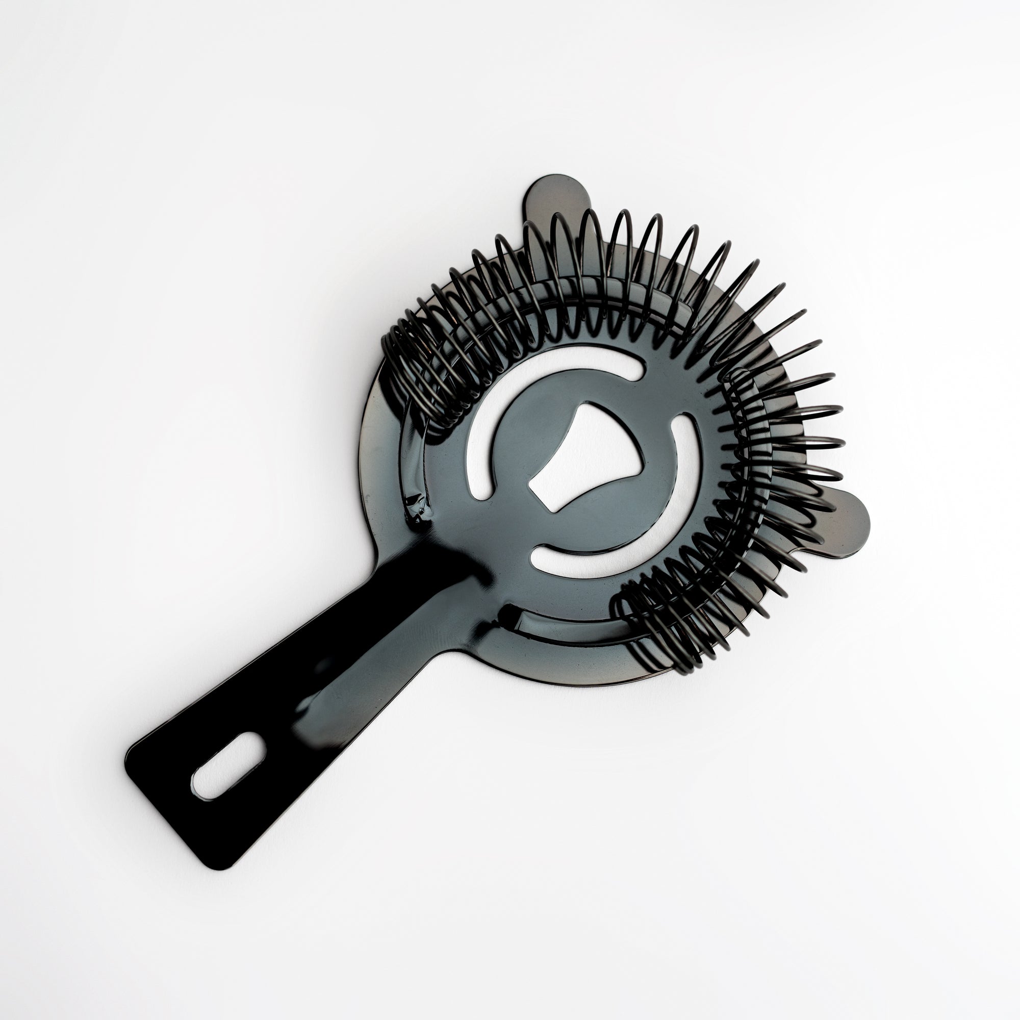 Gunmetal cocktail strainer image from above on a white background. 