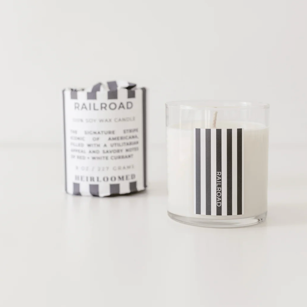 Candle with striped label and packaging on a white background