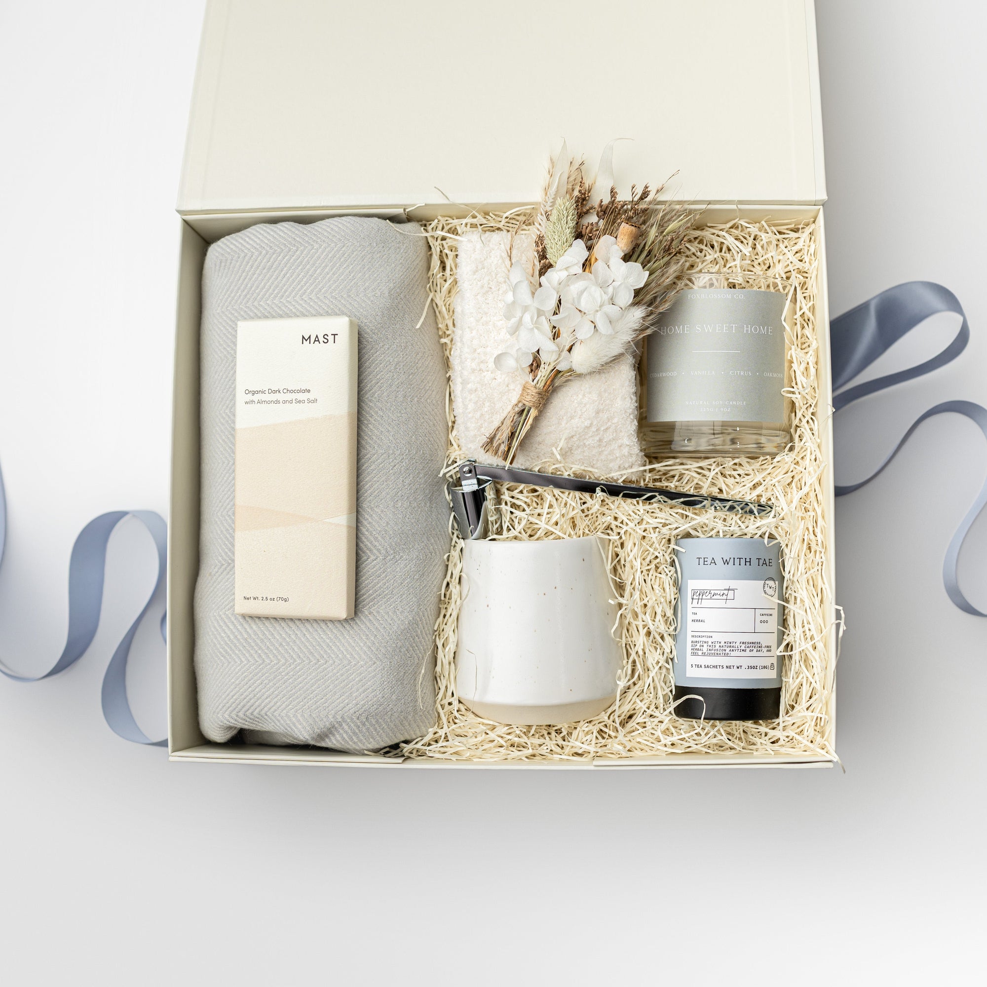 Gift set with candles and a bottle of perfume in a box on a white background