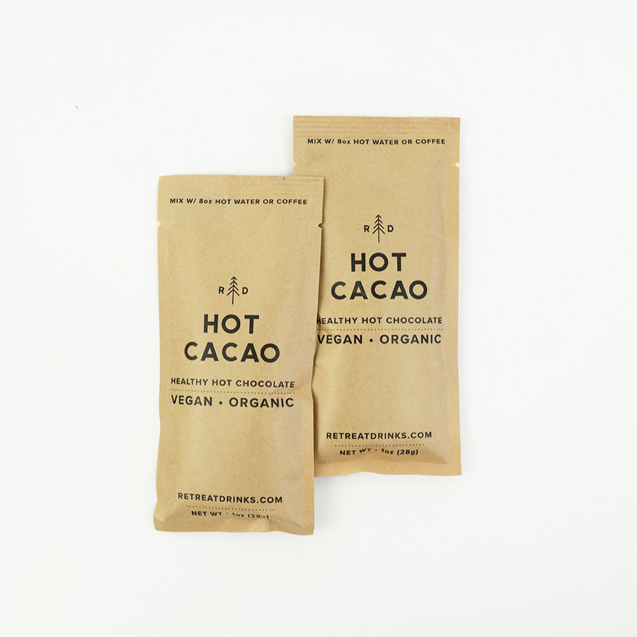Two hot cacao hot chocolate from retreat drinks packet, beige colored with information in black lettering on a white background.