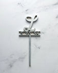 Initial & date wooden cake topper is featured personalized with L and 5.325.24 in silver on a marble like background.
