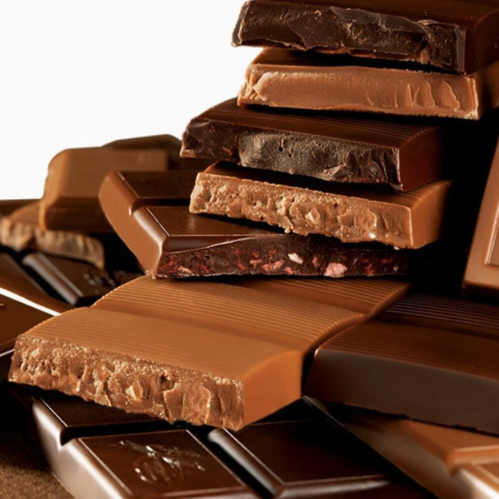 Le Belge pieces milk chocolate bars in display opened caramel and dark chocolate one have some strawberry pieces on a white background. 