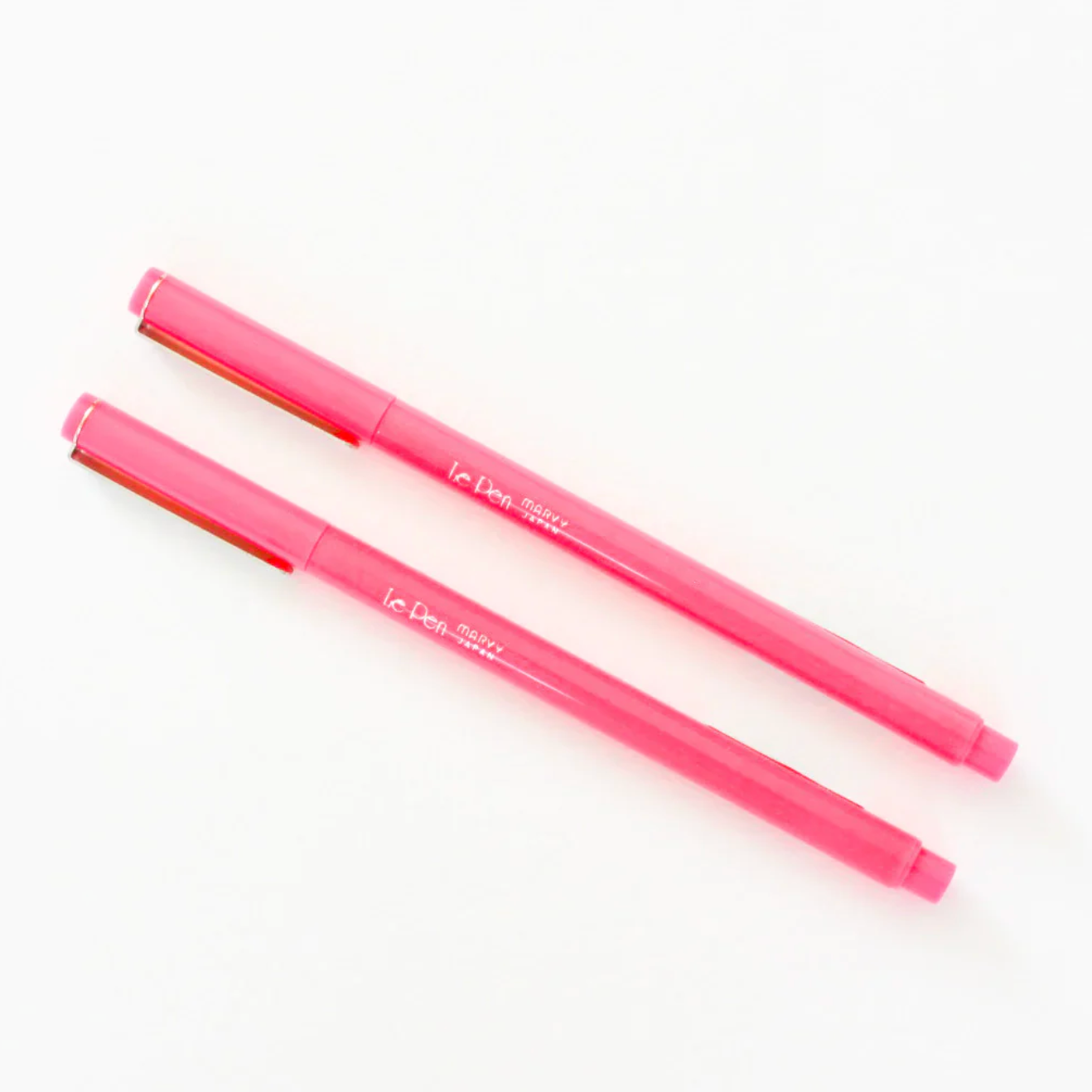 Two pink markers with visible branding on a white background