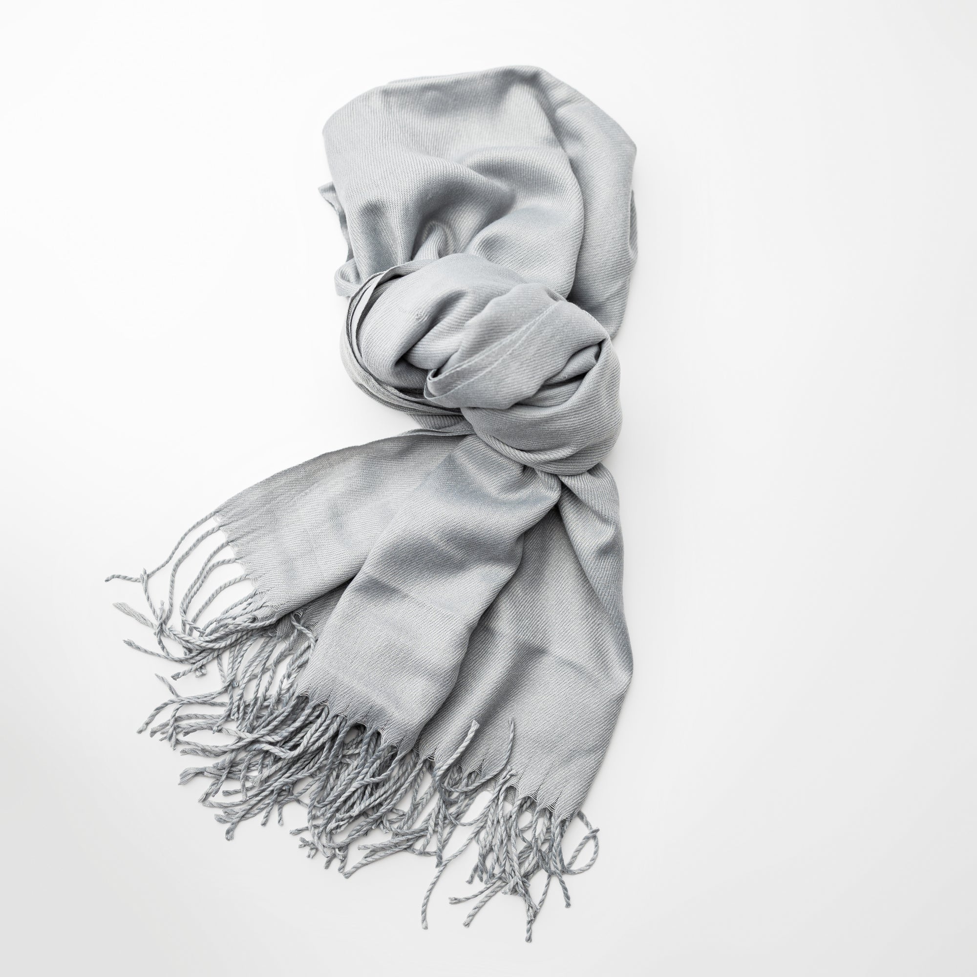 Light grey pashmina with fringed edges on a white background.