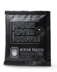 Lua Pour single serving over coffee in its black packaging on a white background.