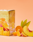 Box of California Gummy Bears with sliced oranges and peaches on a peach background