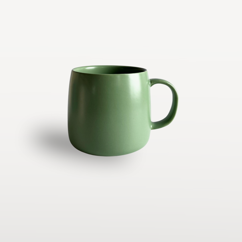 Glossy green ceramic coffee mug with a curved handle, shown on a plain white background.
