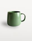 Glossy green ceramic coffee mug with a curved handle, shown on a plain white background.