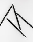 Four minimalist black pens are featured on a white background.