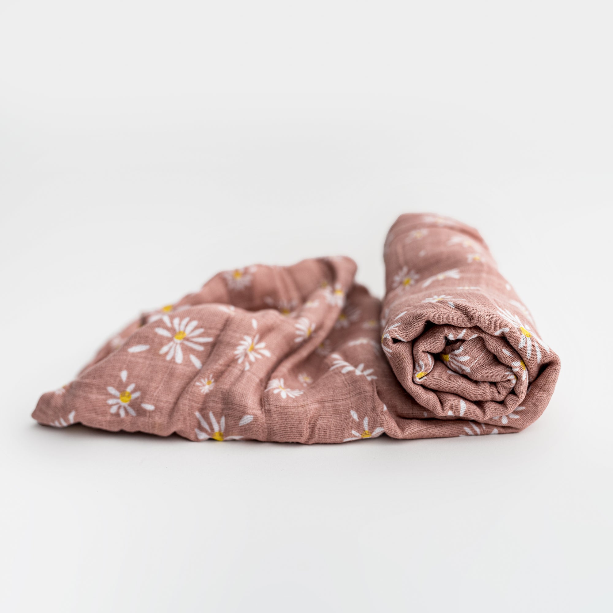 Muslin daises swaddle blanket featured pink with daisy flowers on a white background.