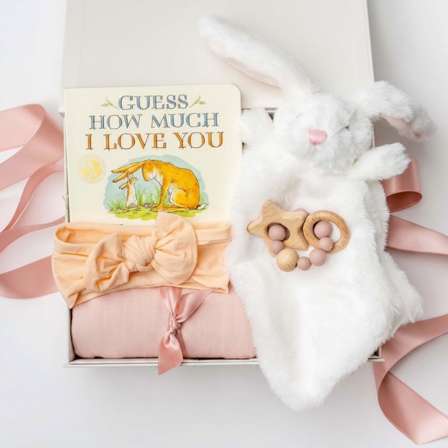 Baby gift set with 'Guess How Much I Love You' book, bunny, headband, and teether in a box.