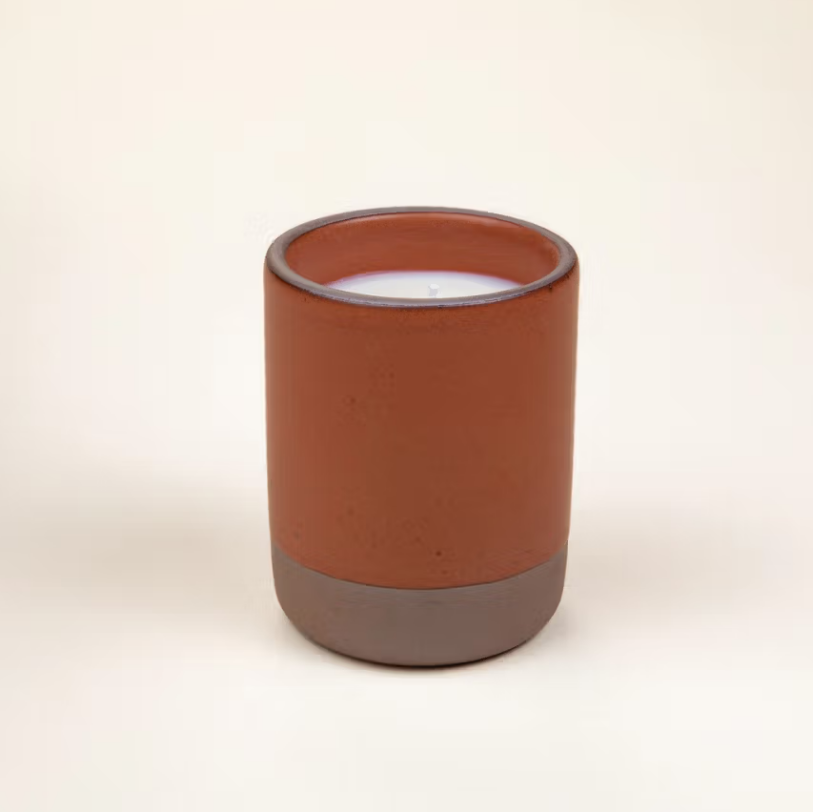 Nightcap candle is featured in its amber ceramic jar and brown bottom on a white background. 