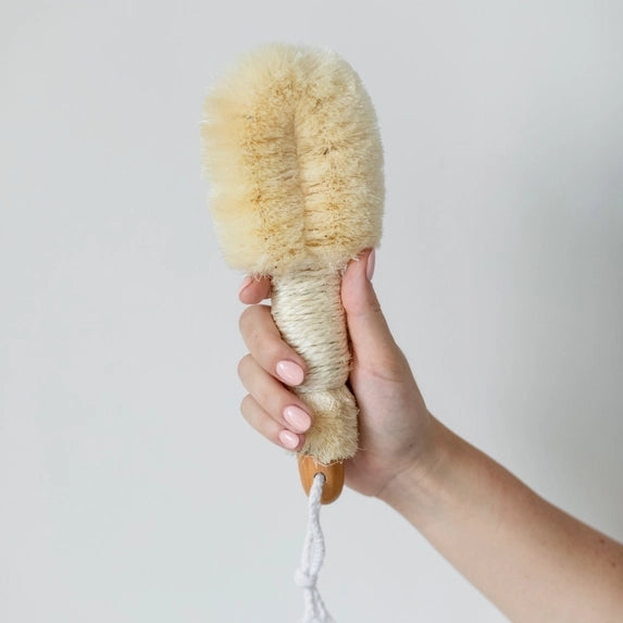 The nordic dry brush featured held by the hand on a white background. 